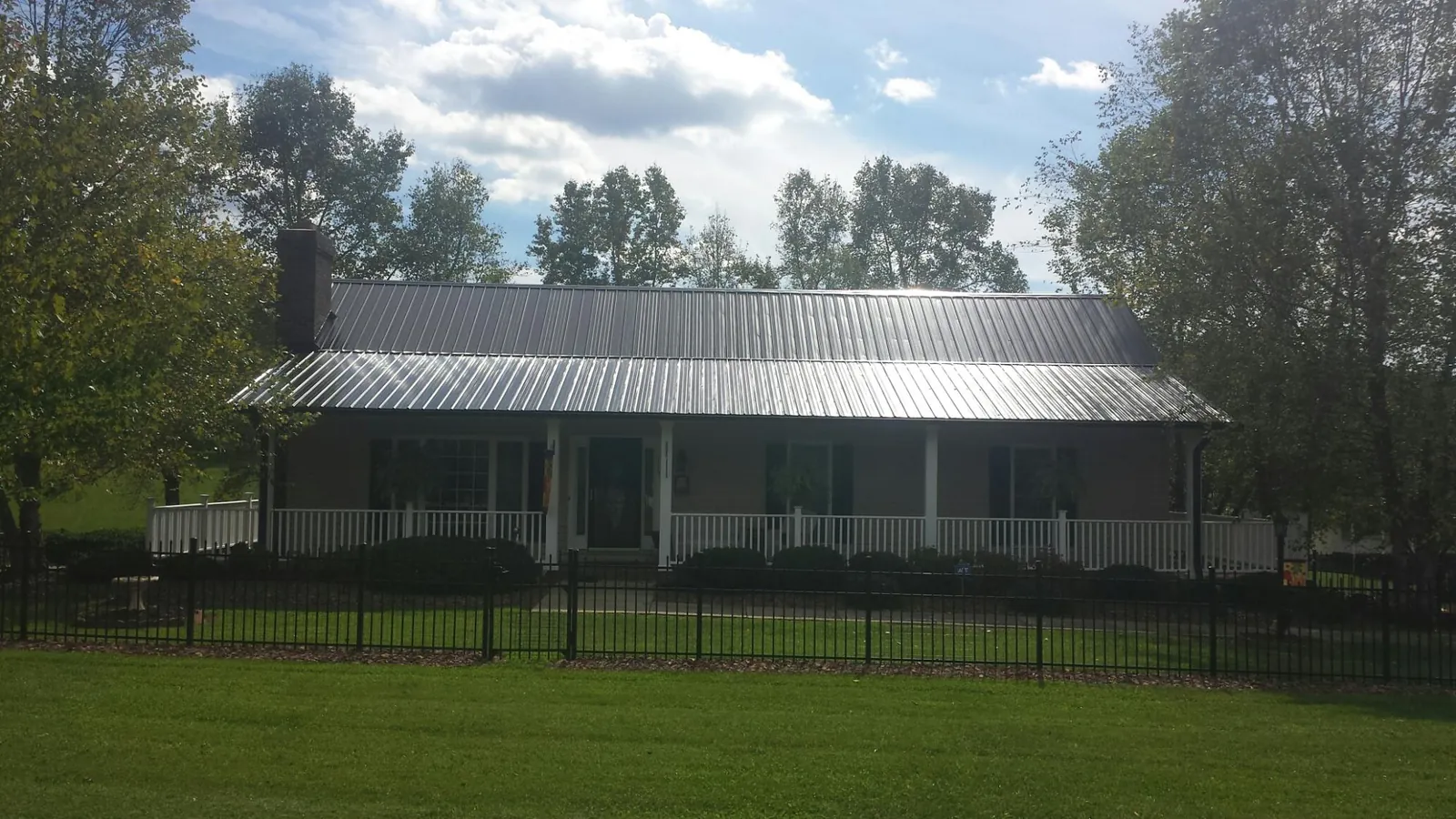 Gray metal roof on a brick ranch with a full width front porch — Gutter Guard Installation work by our crew in Spreckels